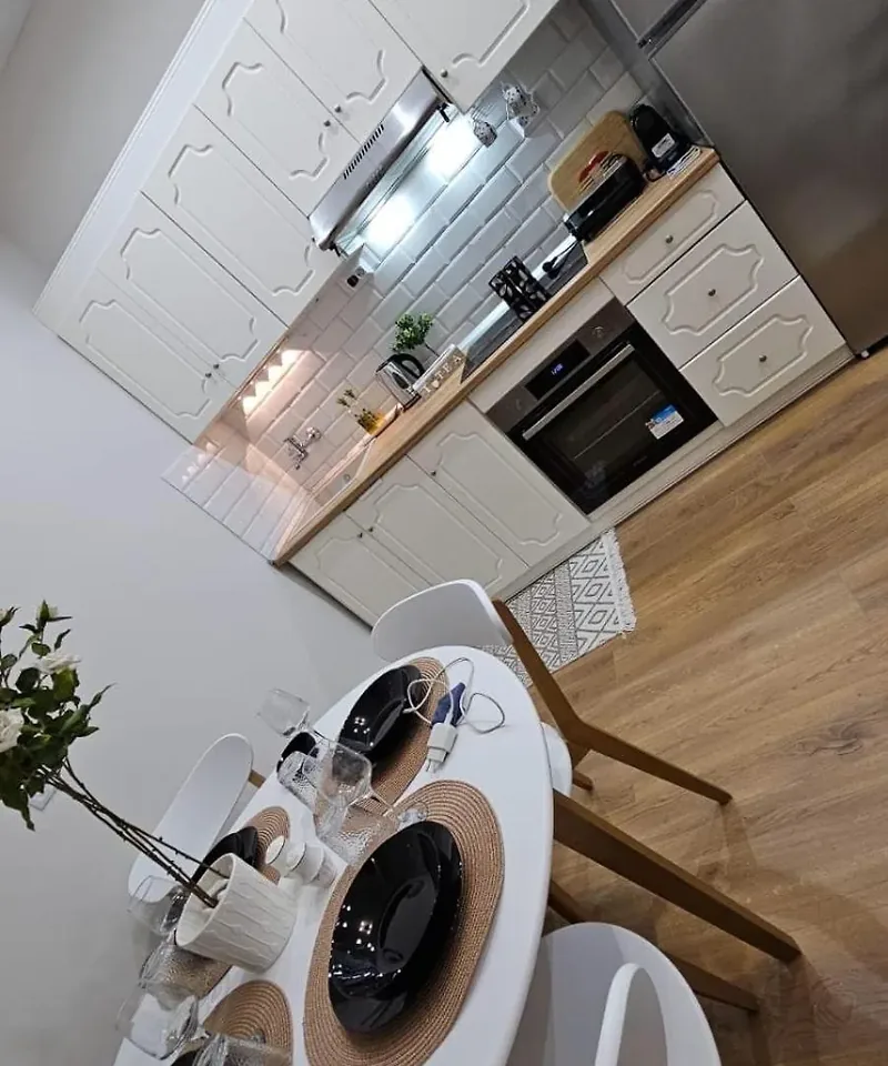 Dining table and white fitted kitchen with oven at Eda House