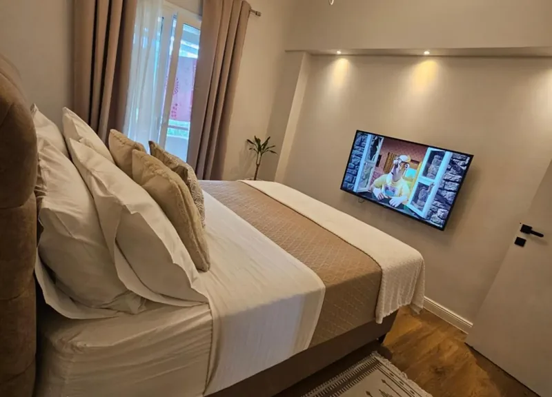 Bedroom at Eda House with a double bed facing a wall-mounted flat-screen TV