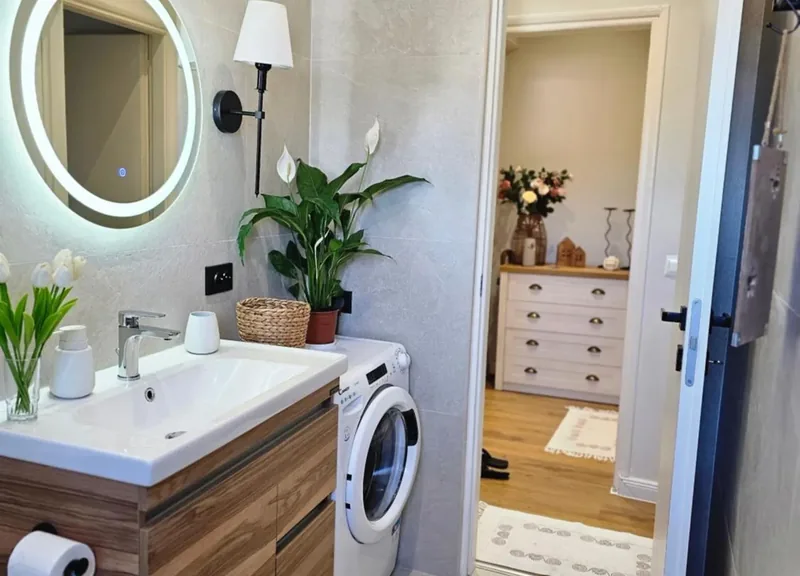 Bathroom at Eda House with vanity, lit mirror and a washing machine