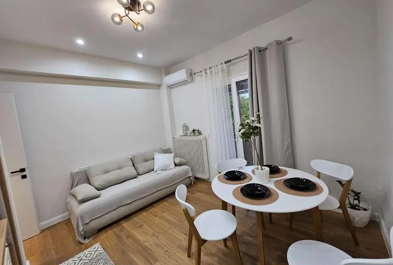 Living room at Eda House with a beige sofa and round dining table set for four